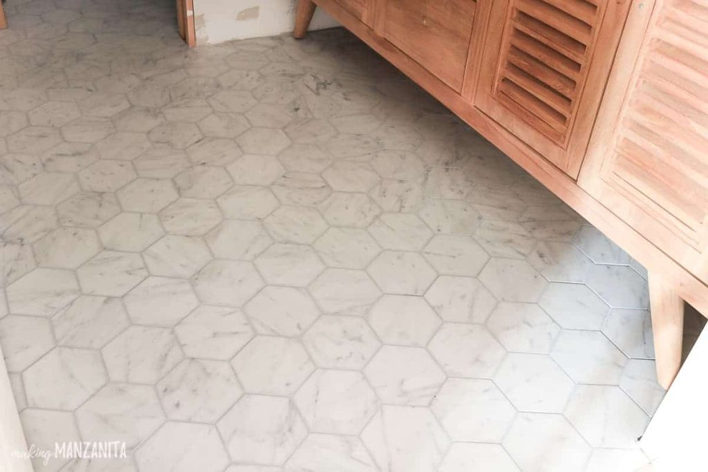 shows white marble hexagonal tile floors under a wood cabinet