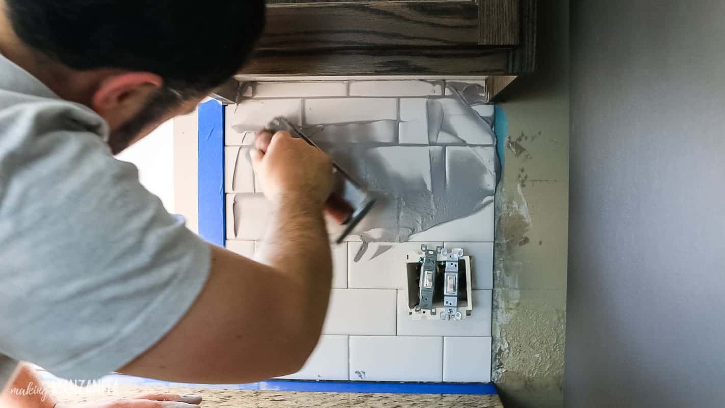 The next step after installing the subway tile is to apply the grout, filling in the gabs between tiles.