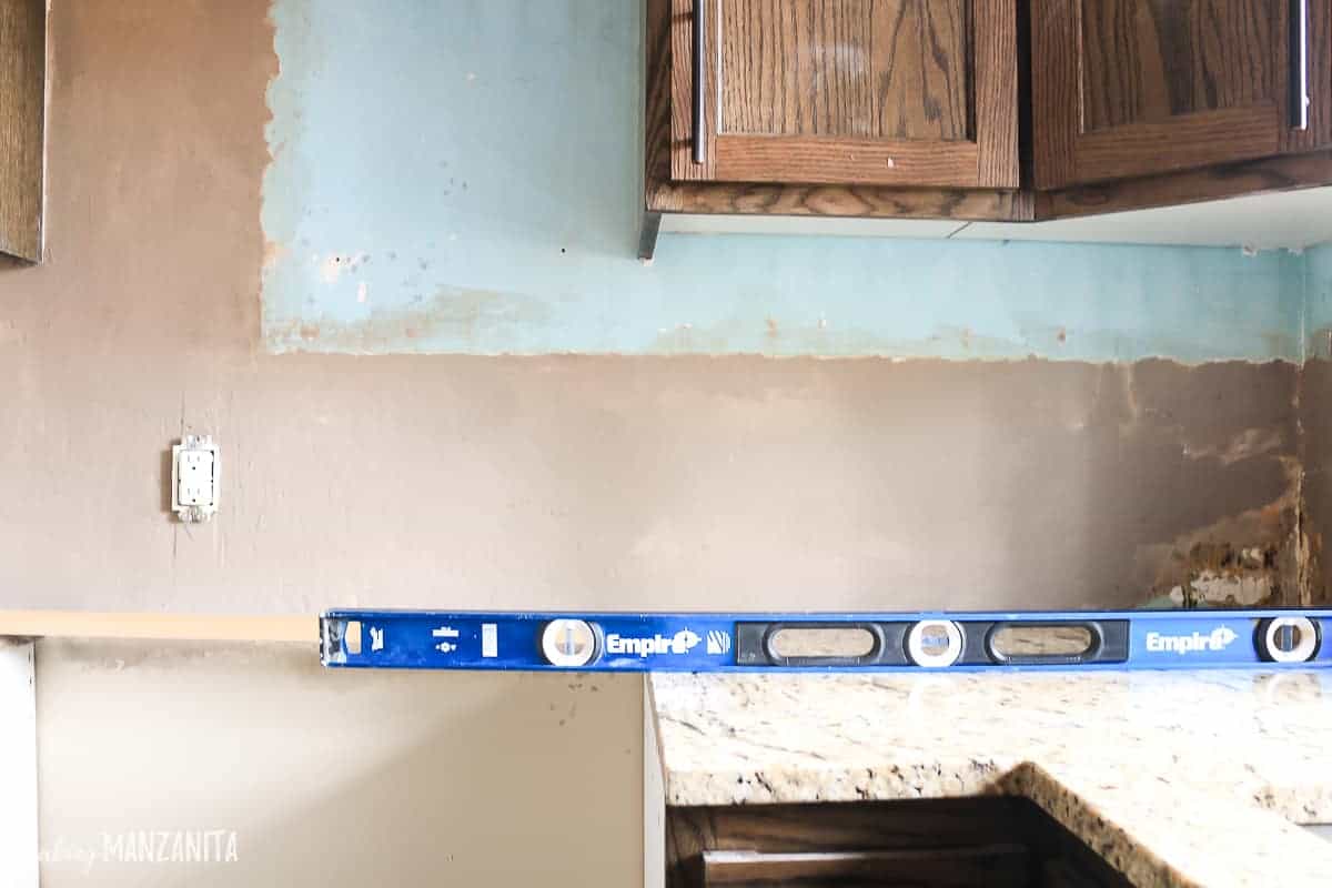 The next step before installing the tile backsplash is to level out the wall where the tile will be installed.