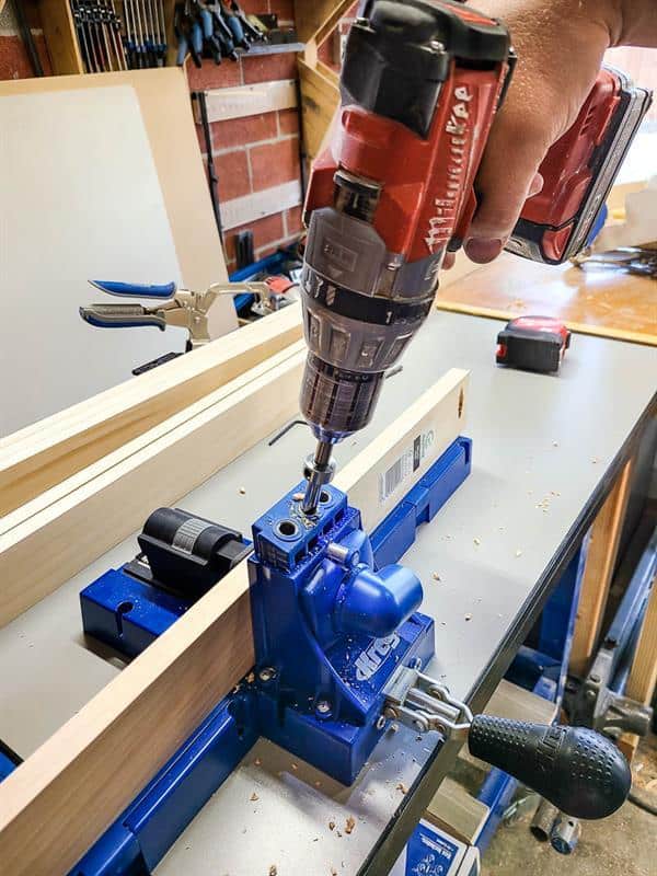 A picture of someone using a drill to create pocket holes for a picture ledge.