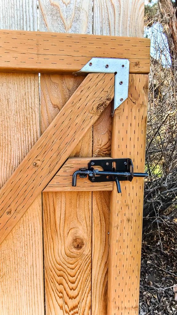 Wooden gate with wood brace and handle and latch attached.